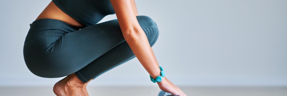 Mujer desenrollando una esterilla de yoga en un ambiente tranquilo.